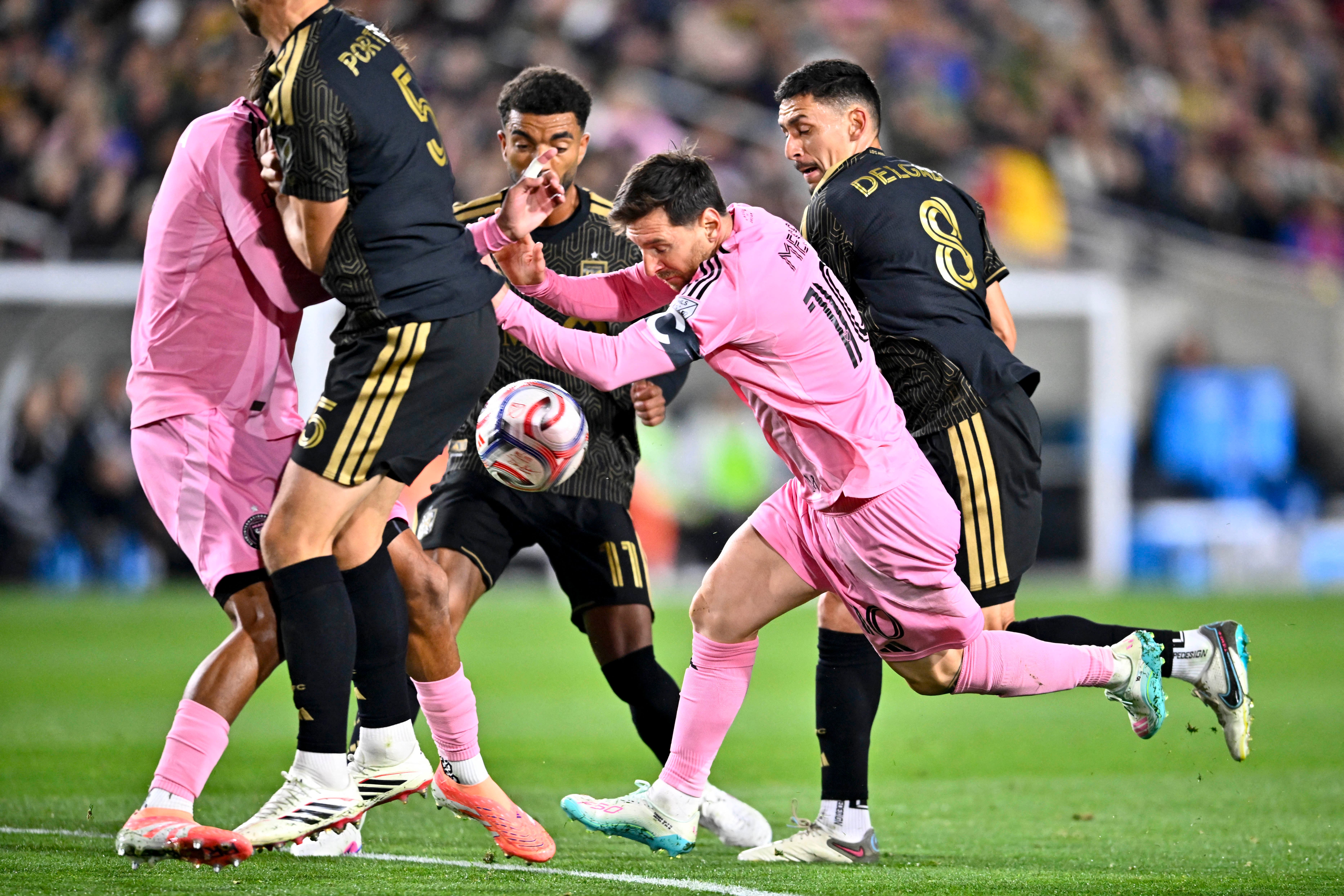 Feb 21, 2026; Los Angeles, California, USA; Inter Miami CF forward Lionel Messi (10) attempts to move the ball through a crowd while defended by Los Angeles FC midfielder Mark Delgado (8) during the second half at Los Angeles Memorial Coliseum. Mandatory Credit: Kelvin Kuo-Imagn Images