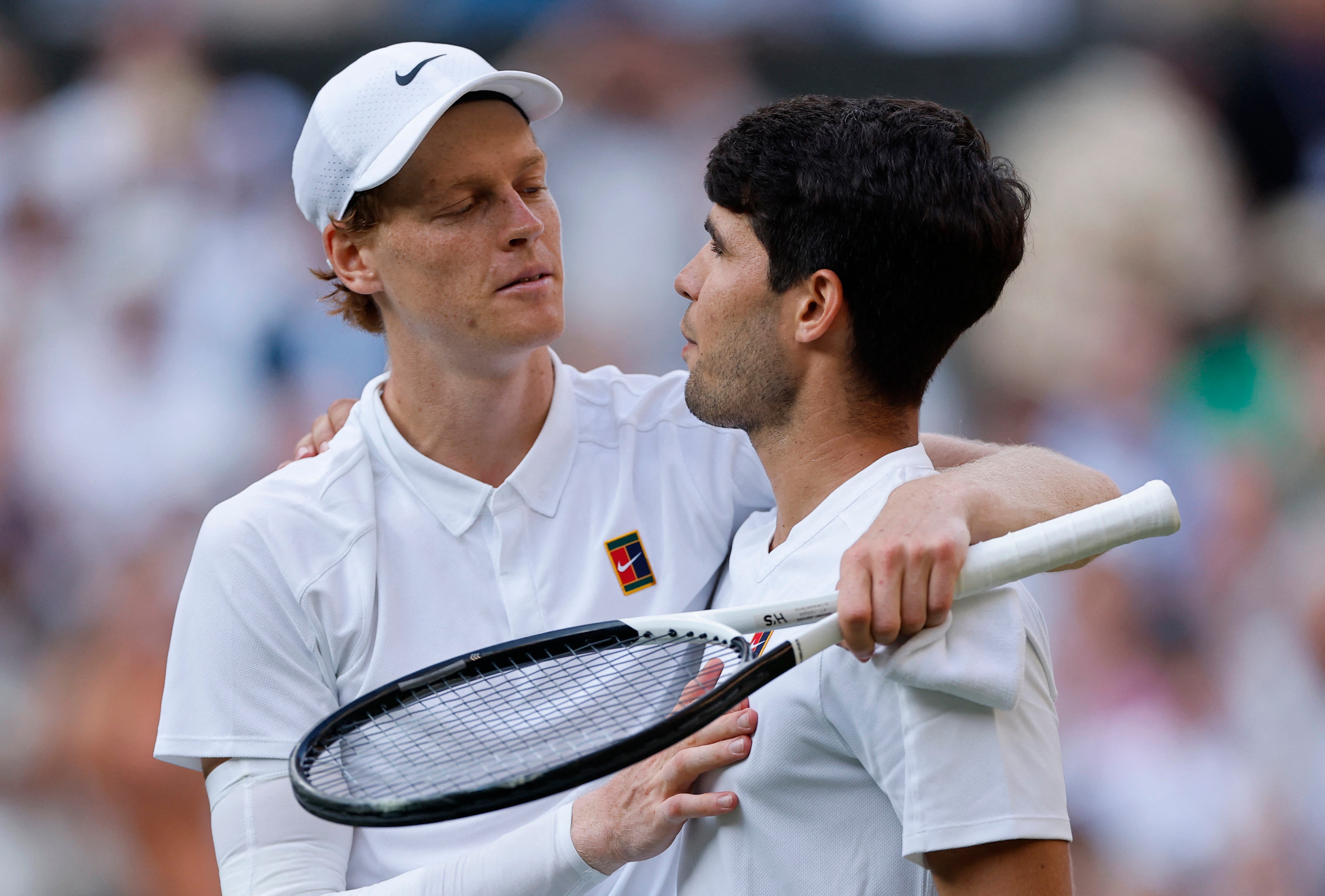 Tennis - Wimbledon - All England Lawn Tennis and Croquet Club, London, Britain - July 13, 2025 Italy's Jannik Sinner reacts with Spain's Carlos Alcaraz after winning the men's final REUTERS/Stephanie Lecocq