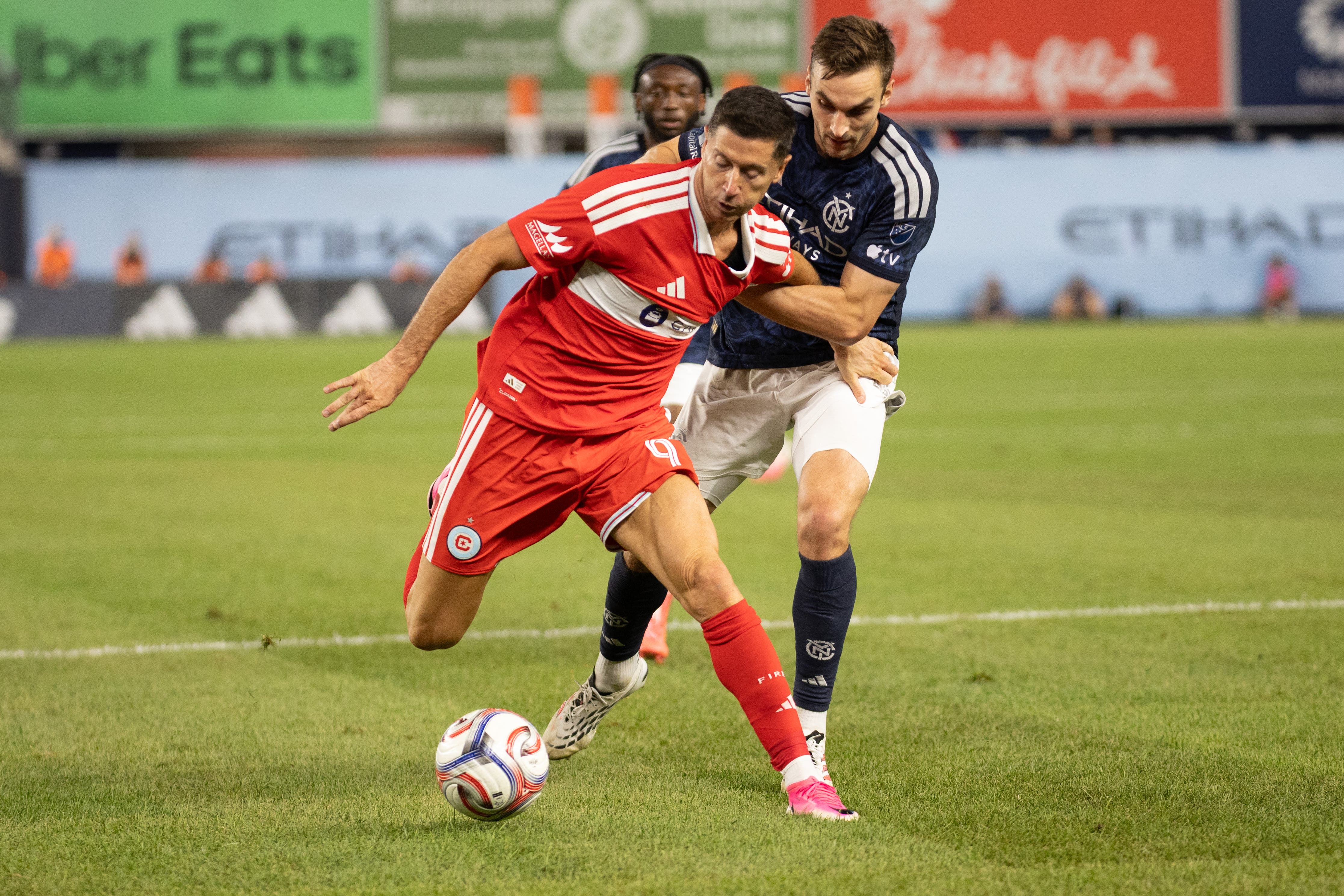Jul 25, 2026; New York, New York, USA; Chicago Fire FC offense Robert Lewandowski (9) and New York City Football Club defense James Sands (6) fight for the ball during the second half at Yankee Stadium. Mandatory Credit: Thomas Salus-Imagn Images