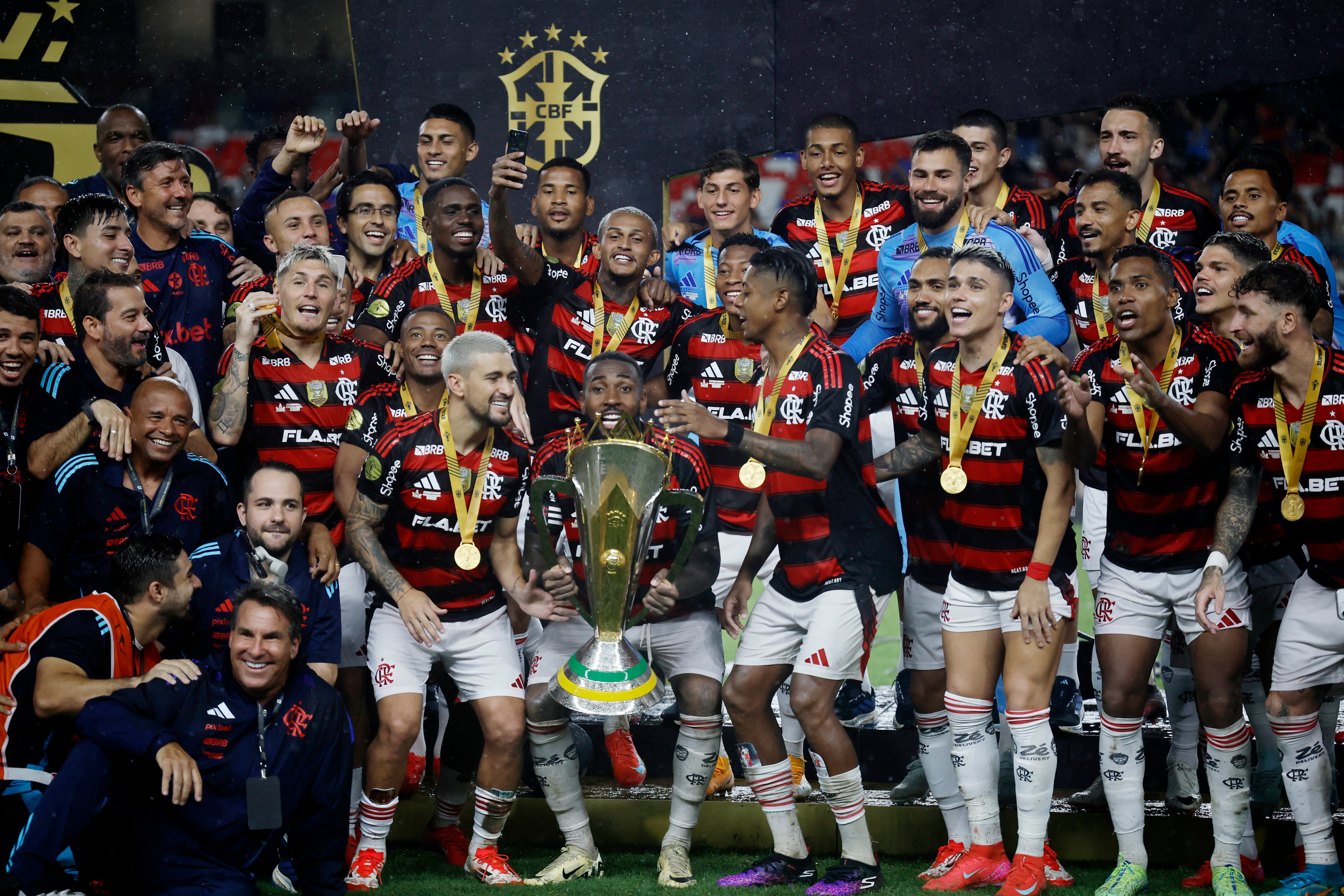 Flamengo's Gerson with teammates celebrate with the trophy after winning the Supercopa do Brasil 