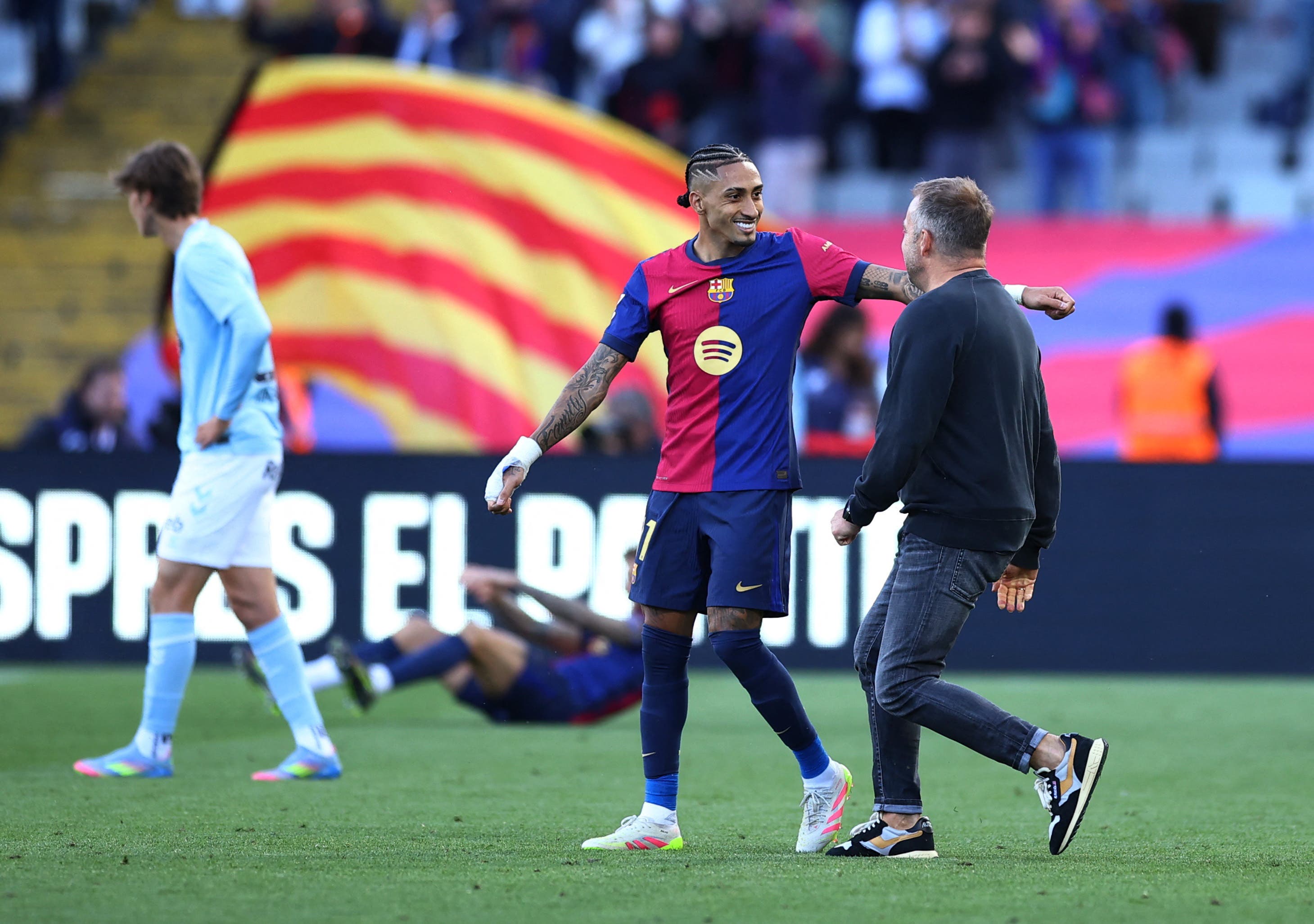 FC Barcelona's Raphinha and coach Hansi Flick celebrate after the match