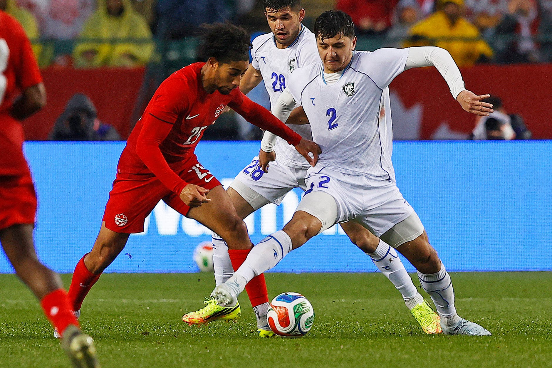 Jun 1, 2026; Edmonton, Ontario, CAN; Team Canada midfielder Nathan Saliba (25) carries the ball past Uzbekistan defender Abdukodir Khusanov (2) /during the second half at Commonwealth Stadium. Mandatory Credit: Perry Nelson-Imagn Images