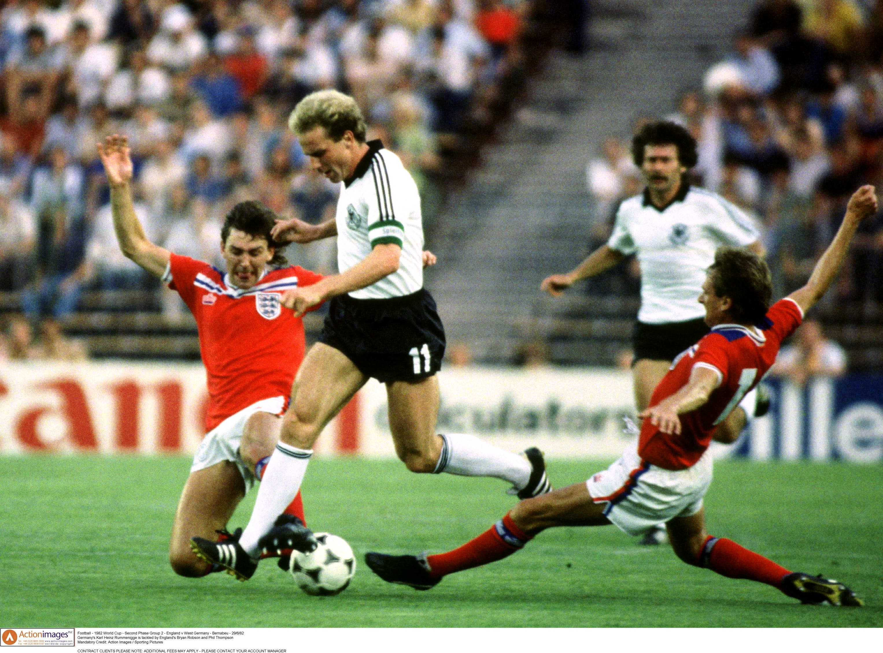 Football - 1982 FIFA World Cup - England v West Germany - Group B - Estadio Santiago Bernabeu - 29/6/82 Germany's Karl Heinz Rummenigge is tackled by England's Bryan Robson and Phil Thompson Mandatory Credit: Action Images / Sporting Pictures CONTRACT CLIENTS PLEASE NOTE: ADDITIONAL FEES MAY APPLY - PLEASE CONTACT YOUR ACCOUNT MANAGER Santiago Bernabeu
