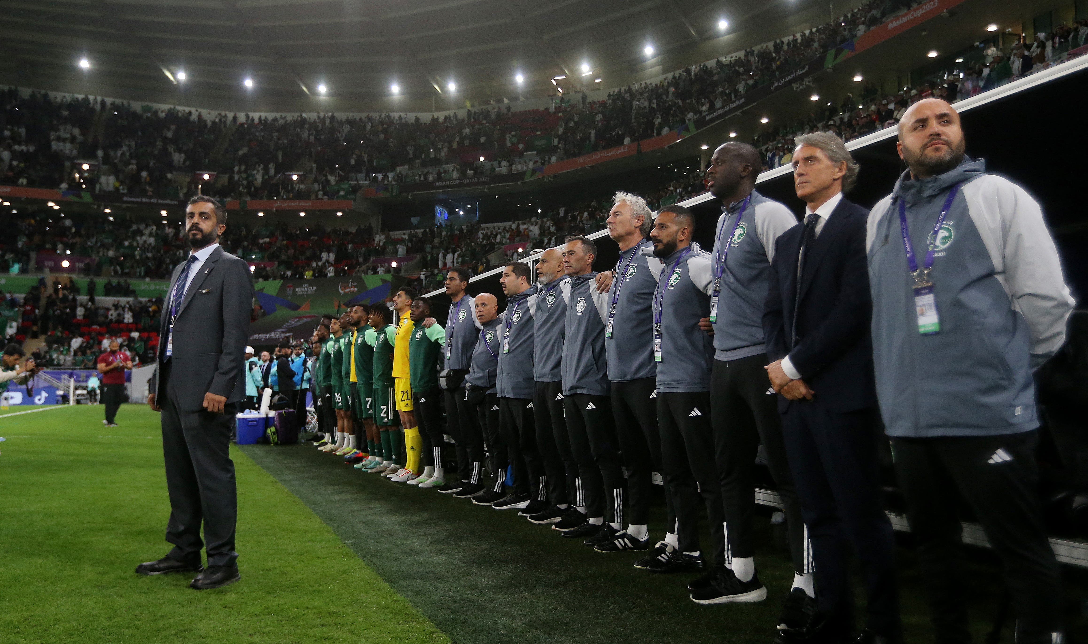 Soccer Football - AFC Asian Cup - Group F - Kyrgyzstan v Saudi Arabia - Ahmad bin Ali Stadium, Al Rayyan, Qatar - January 21, 2024 Saudi Arabia coach Roberto Mancini and assistant coach Yaya Toure during the national anthems before the match REUTERS/Ibraheem Al Omari

