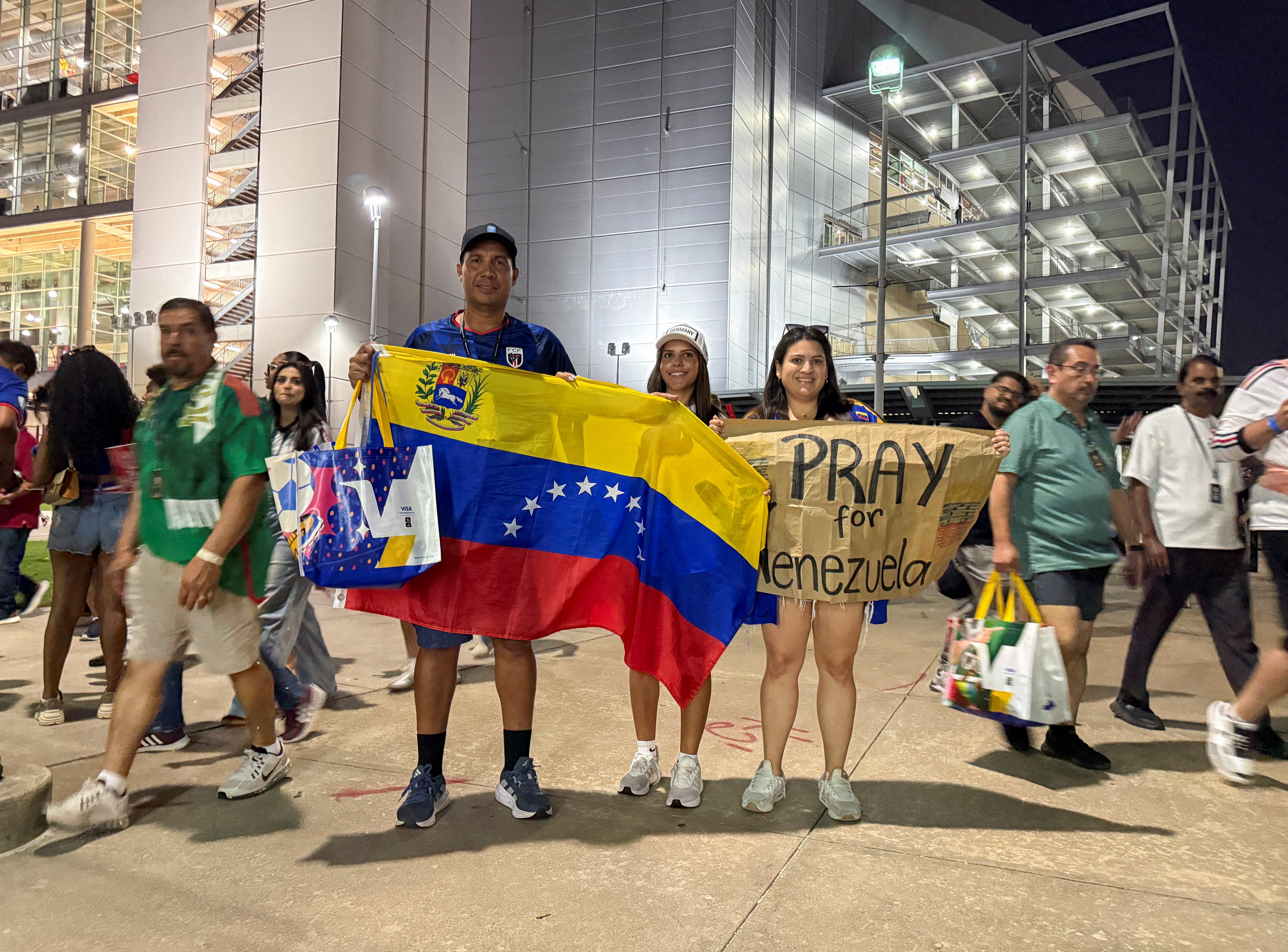 Attendees of the FIFA World Cup match between Cape Verde and Saudi Arabia pose while holding the flag of Venezuela and a sign reading "Pray for Venezuela", in Houston, Texas, U.S., June 26, 2026. Picture taken with a mobile phone. REUTERS/Evan Garcia

