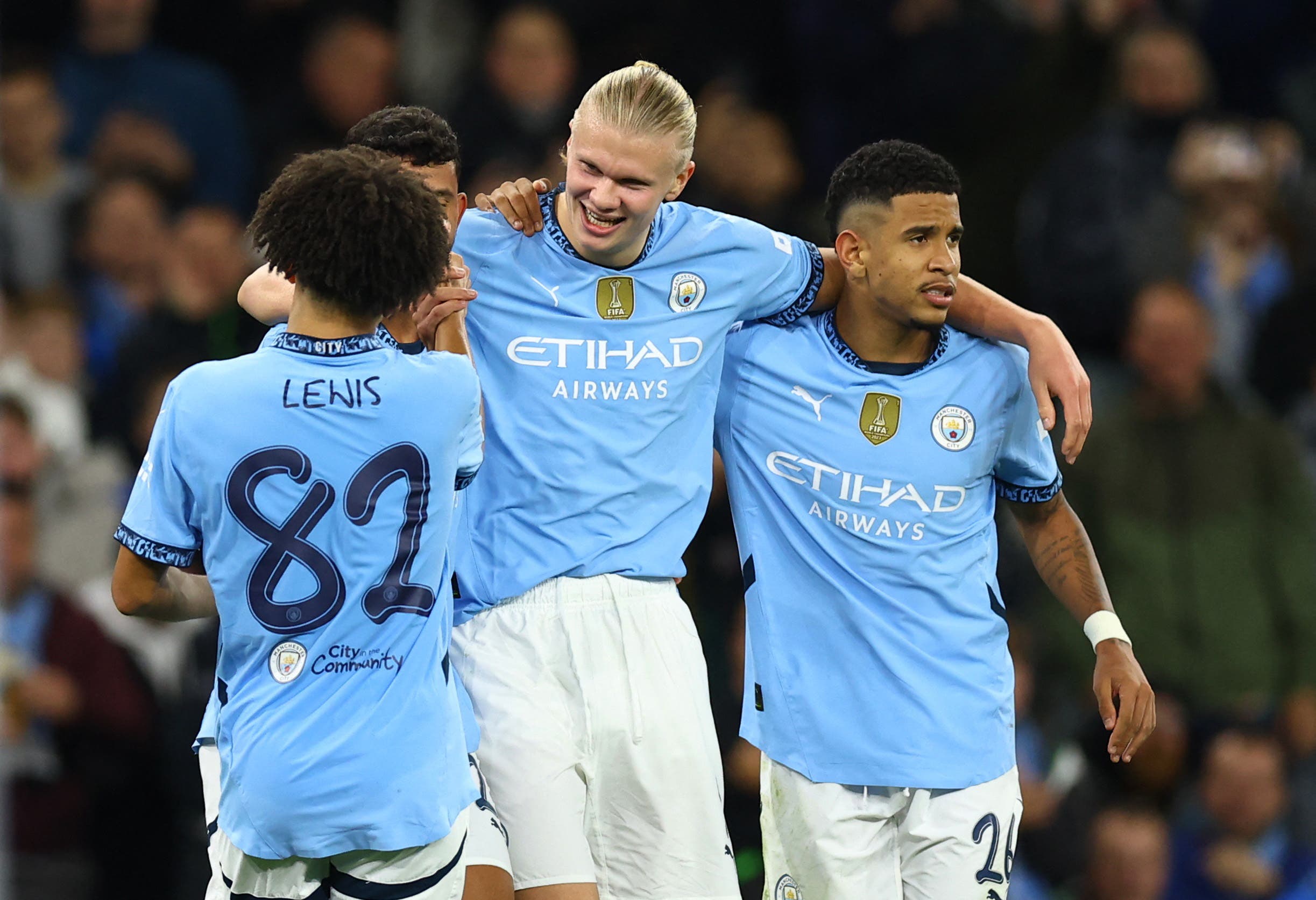 Savinho celebrating a Manchester City goal with Erling Haaland and Rico Lewis.