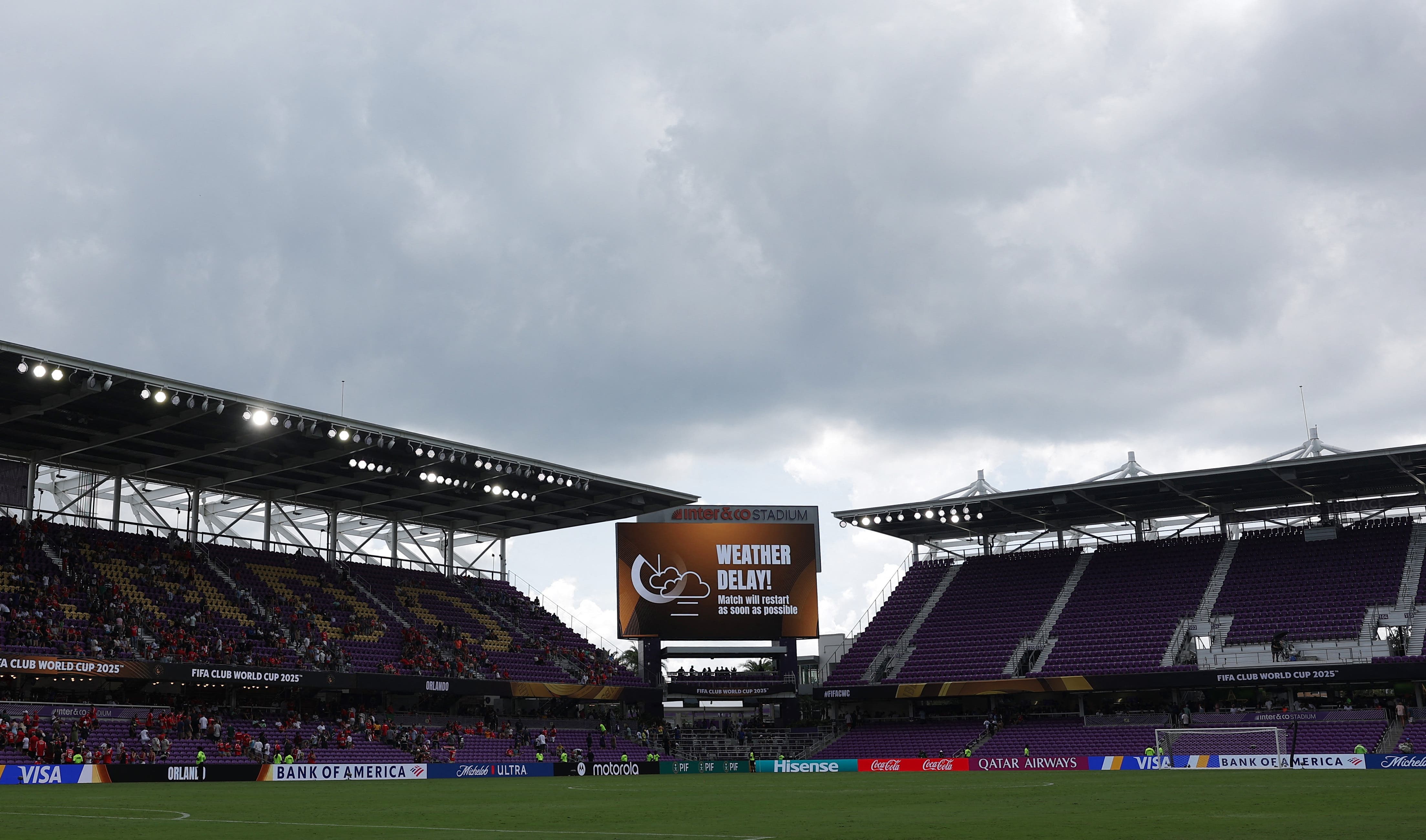 The big screen displays a weather delay message 