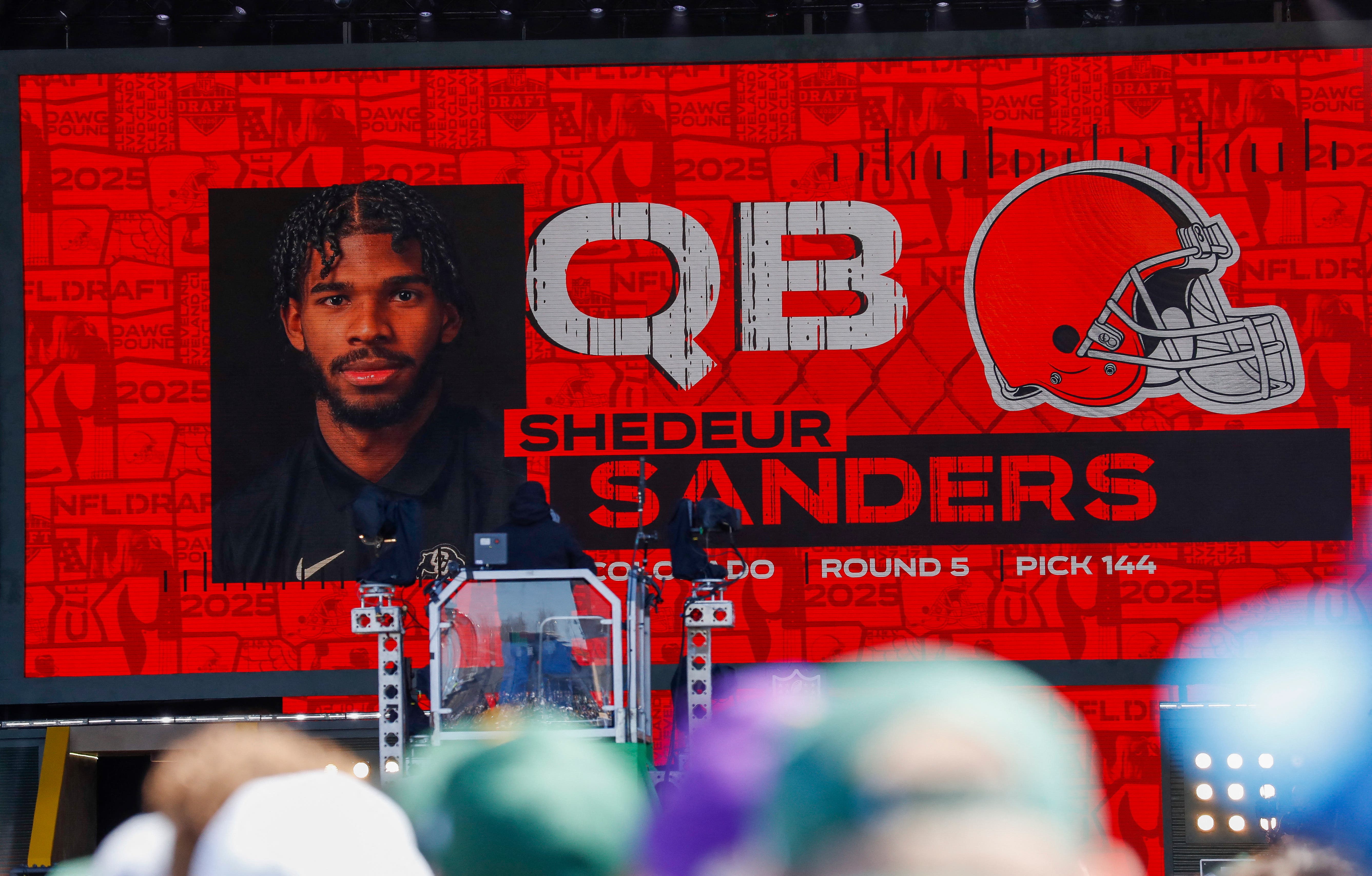 A graphic announcing Colorado quarterback Shedeur Sanders’ selection by the Cleveland Browns with the 144th overall pick is seen in the Draft Theater during the third day of the 2025 NFL Draft at Lambeau Field.