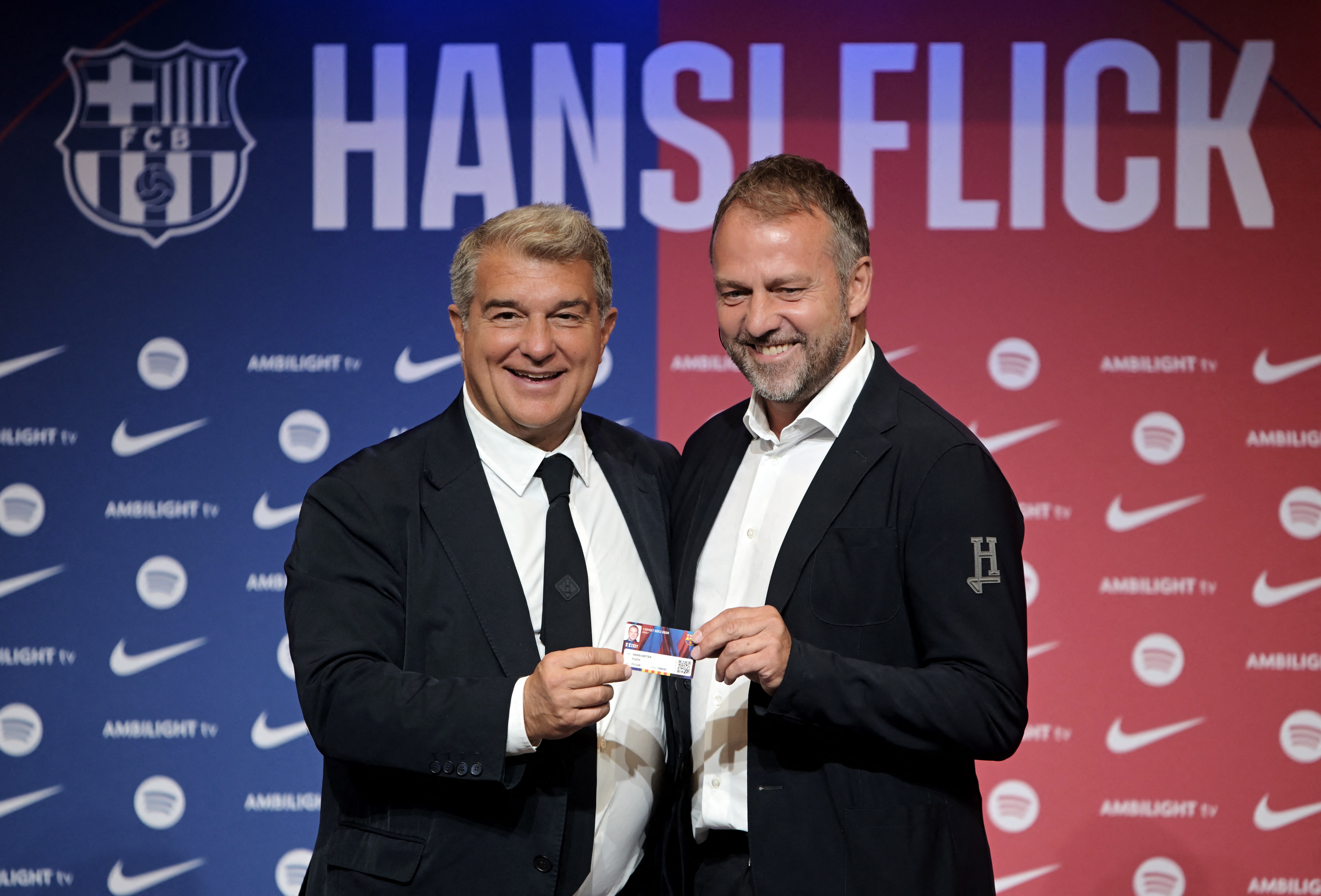New FC Barcelona coach Hansi Flick holds an FC Barcelona shirt with president Joan Laporta as they pose during the presentation 