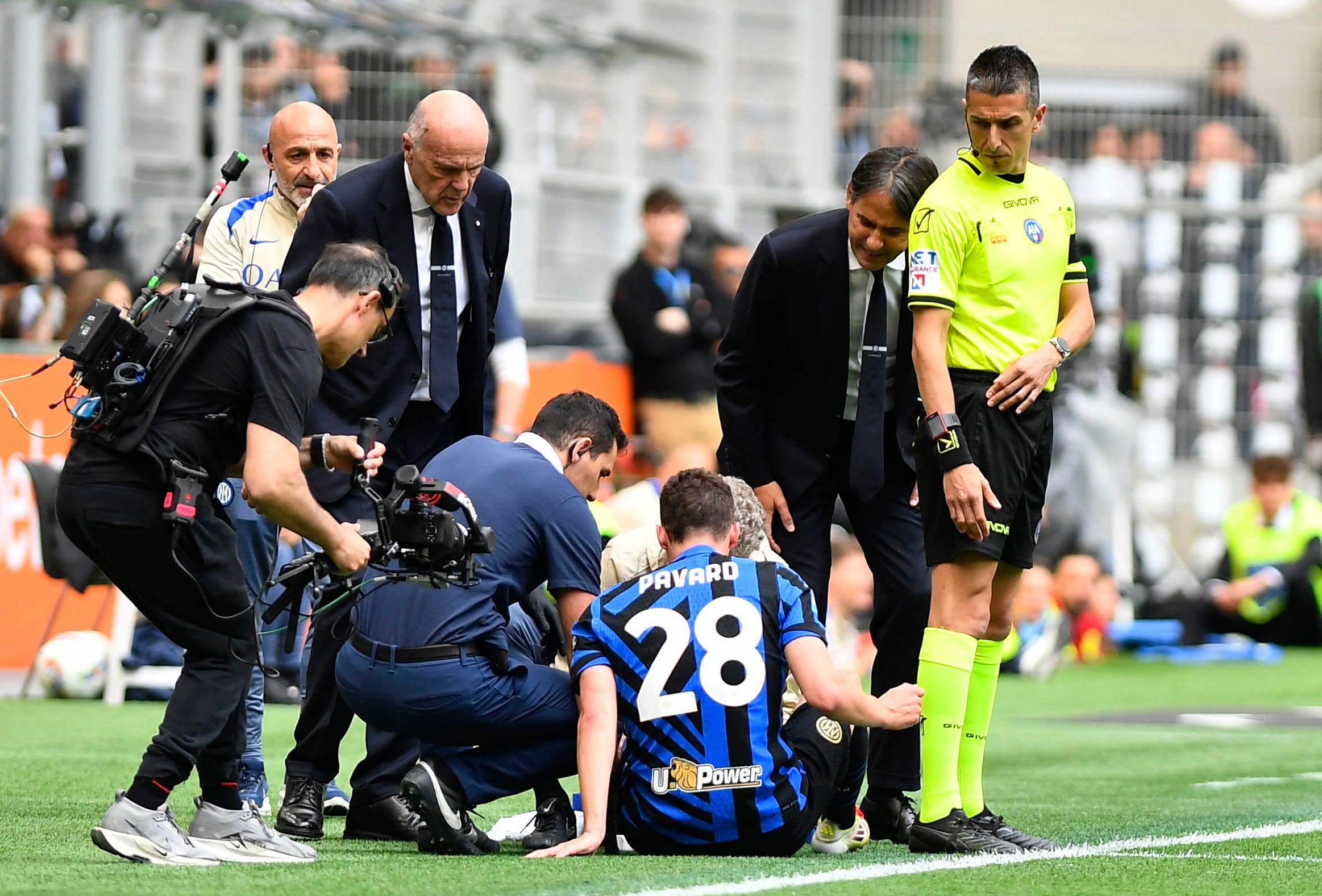 Inter Milan's Benjamin Pavard receives medical attention after sustaining an injury as coach Simone Inzaghi looks on