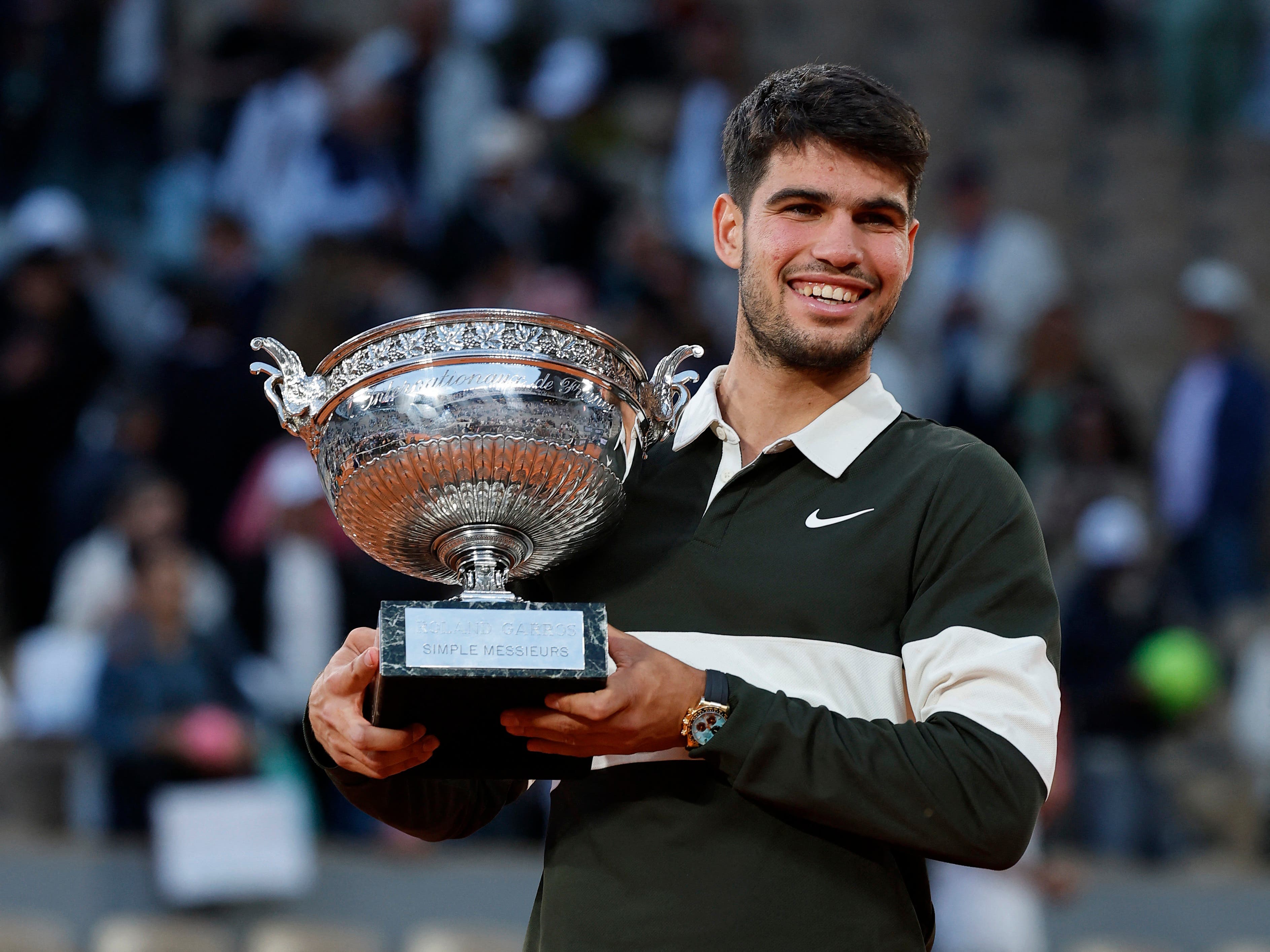 Spain's Carlos Alcaraz celebrates with the trophy after winning the men's singles final against Italy's Jannik Sinner