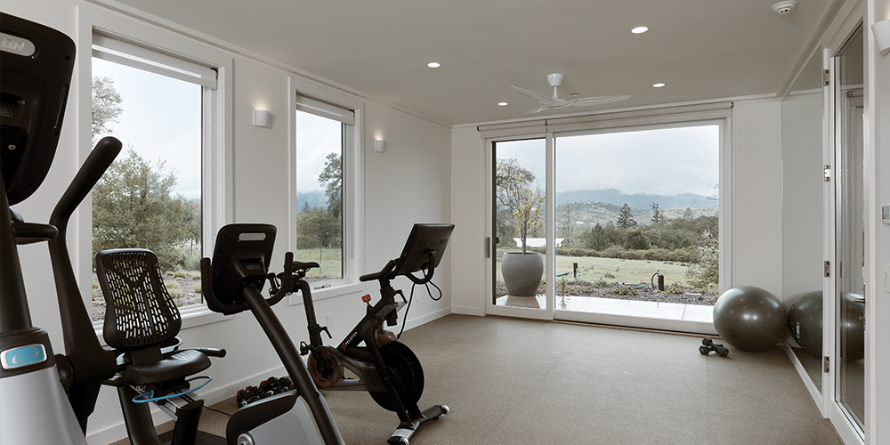 Home gym with large windows and a sliding patio door