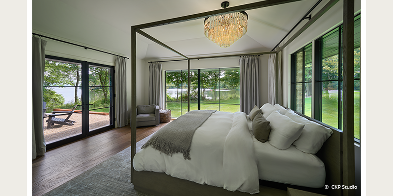 renovated bedroom with expansive windows and door to patio.