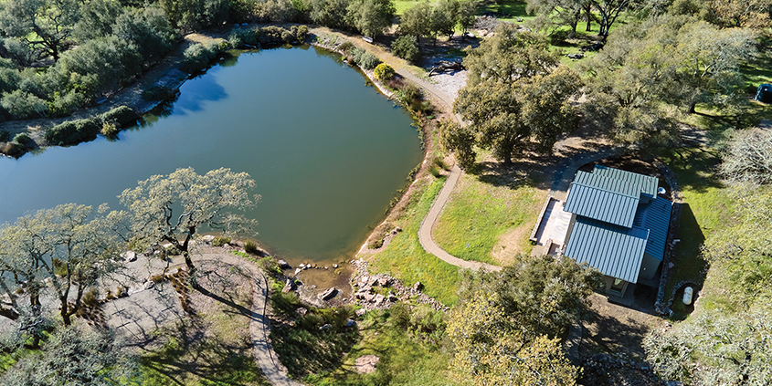 Exterior drone shot of home and pond after renovation