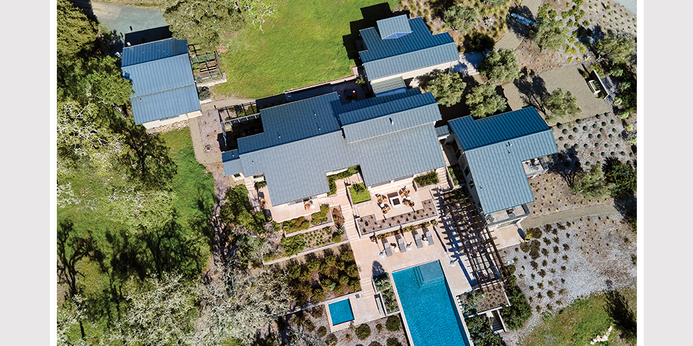 Drone shot of home after renonvation, featuring back patio and pool