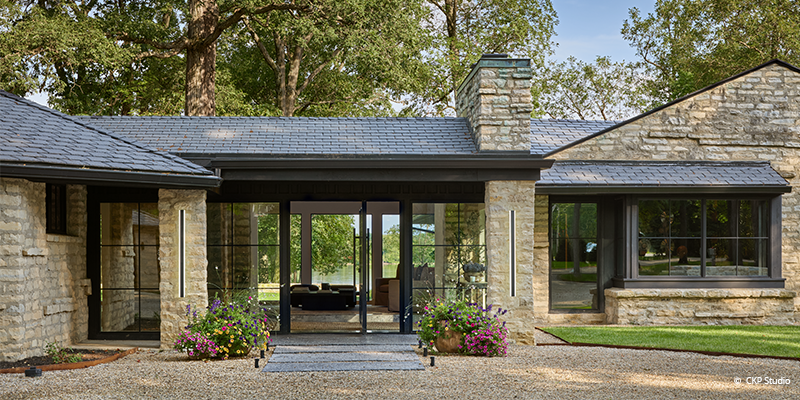 Front of fully remodeled home; customized with expansive windows and beautiful stonework.