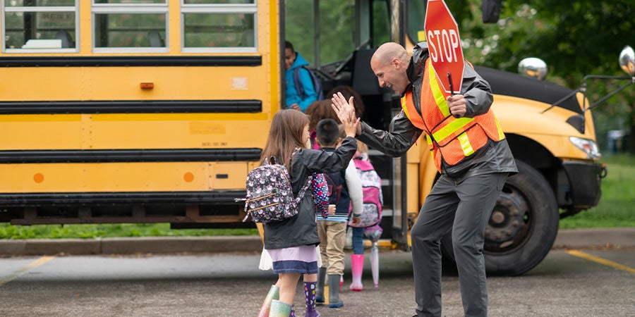 Kids high fiving crossing guard