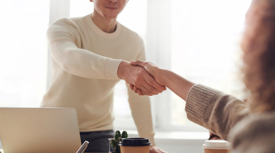 male shaking hands with female for interview