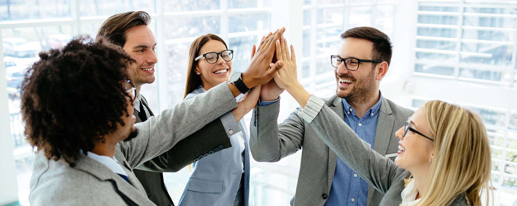 Team members smiling and high fiving each other