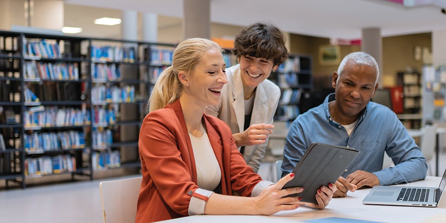 Community college faculty chatting in the library