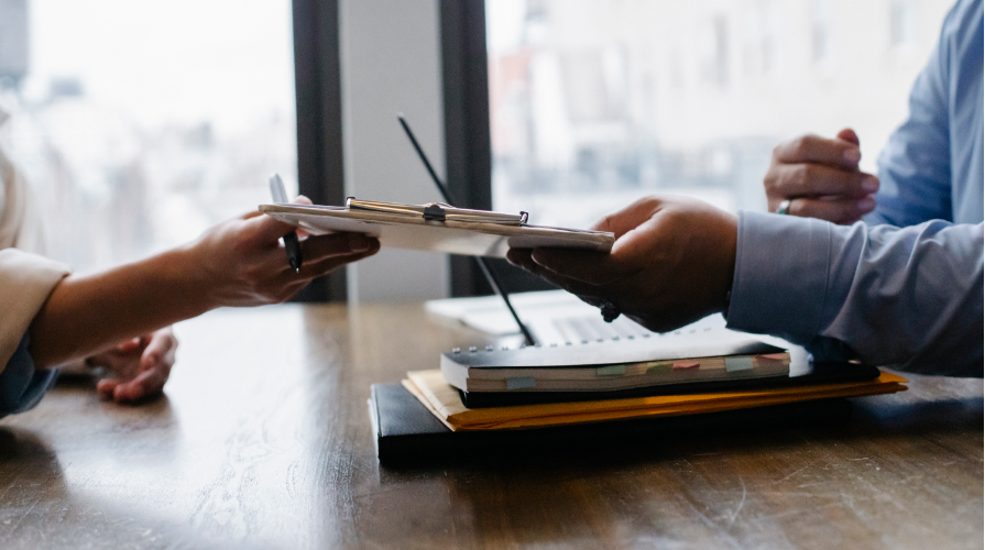 photo of a clipboard being passed over a desk