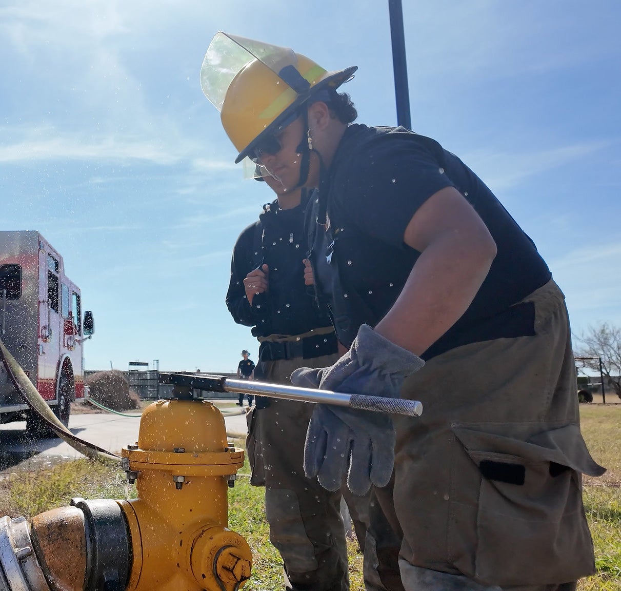 A student in the Firefighter Academy gets direct training on handling a fire hydrant.