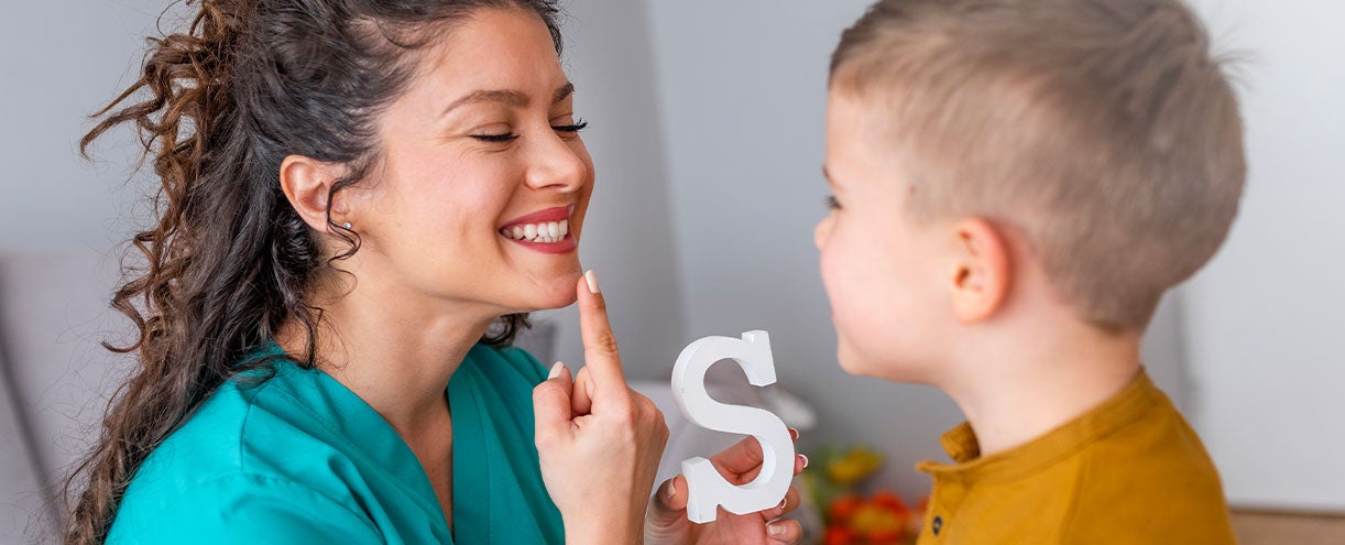 Speech teacher works with student.