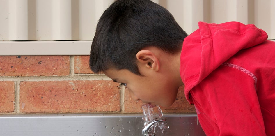 Student drinking from fountain