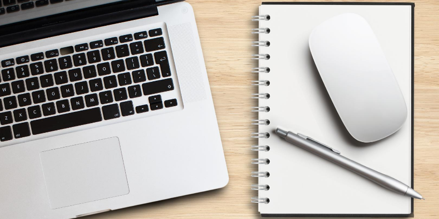 Image showing a laptop keyboard, notebook, mouse and a pen
