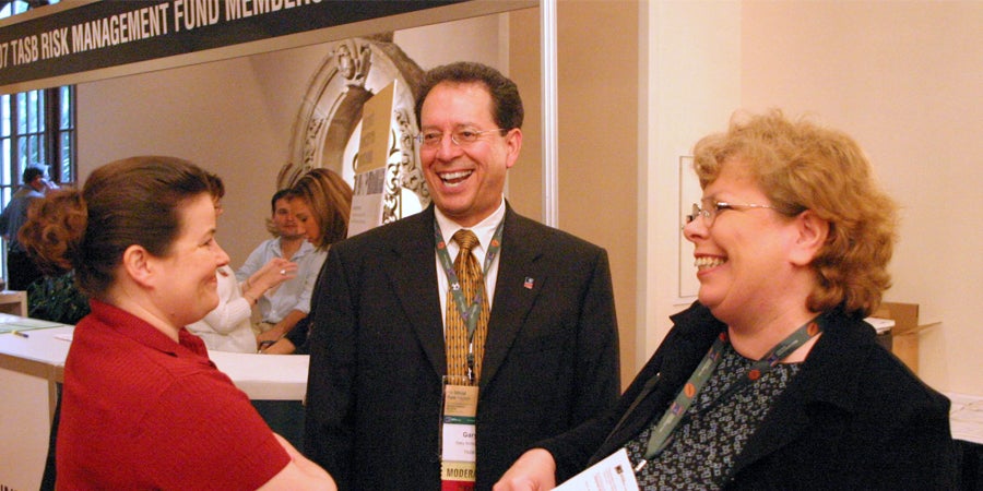 photo of two women and a man smiling and laughing together at a risk management fund conference