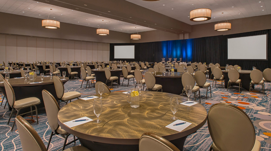 photo of a hotel conference room filled with large round tables 