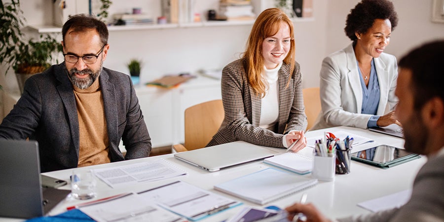 Two men and two women at meeting table