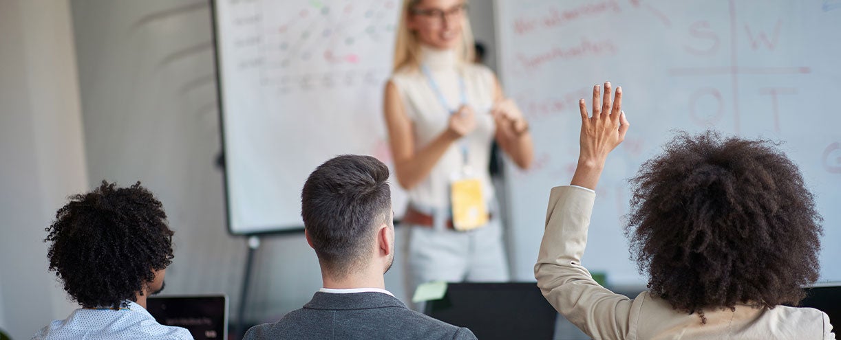 Three people listen to a presentation