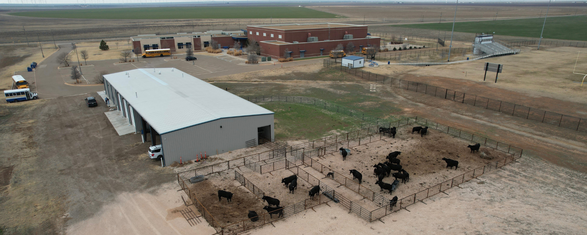 School property with cattle company in aerial shot.