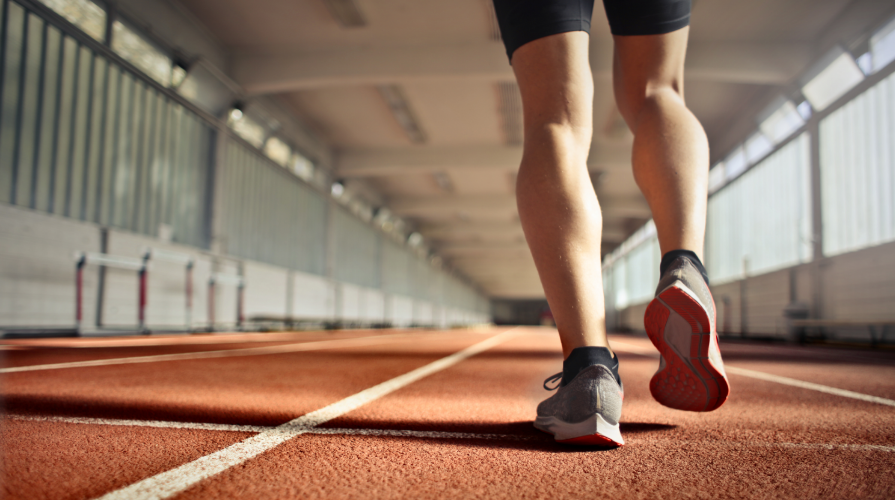 photo of an athlete walking or jogging on an orange track