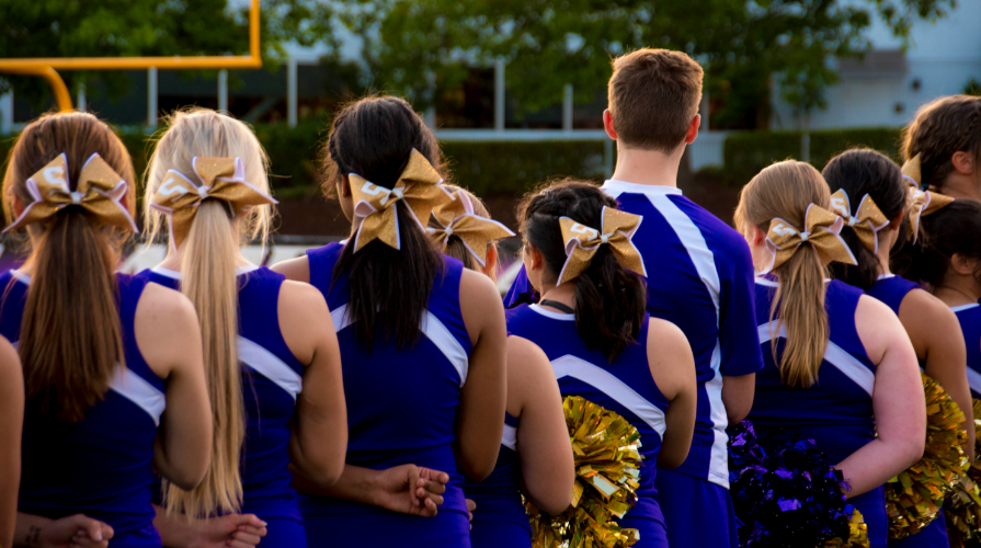 Cheer team standing on football field