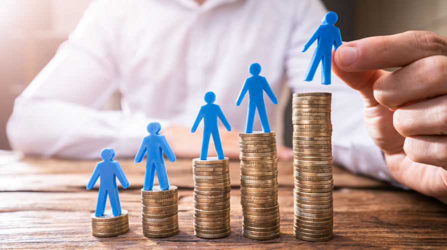 Stacks of coins in increasing amounts with a blue person figure on each stack.