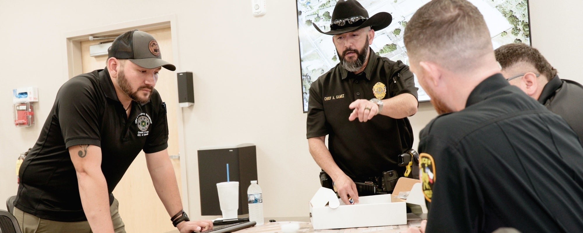 Beeville ISD Police Chief Art Gamez (in hat) conducts a table-top safety training exercise. Photo by TASB Media Services.