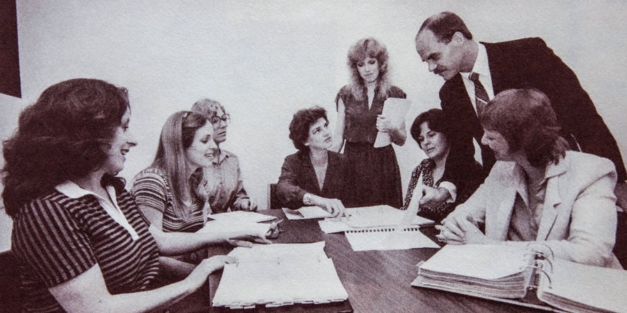 Black and white photo of the TASB Policy Service team working together on updating the policy manual in 1982. 
