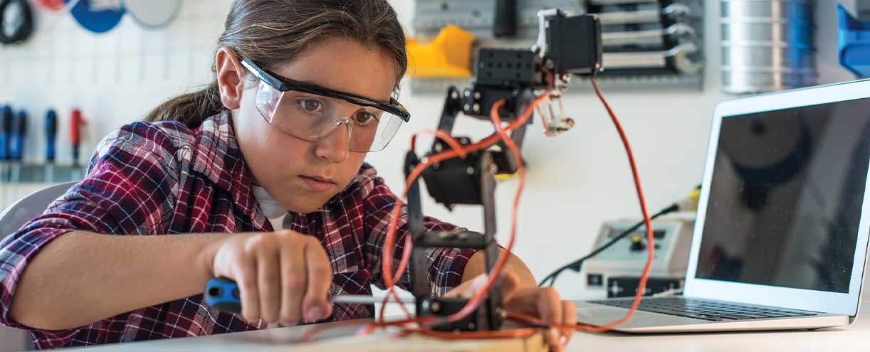 A young student works on a project in a robotics design class.