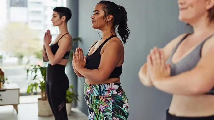 Three female friends doing a yoga class together