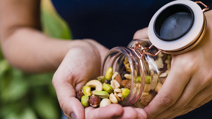 A close up shot of a jar full of mixed nuts.
