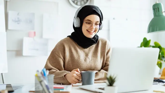 Young woman at work on a video conference drinking a cup of tea