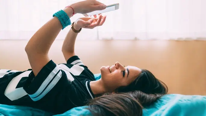 Young woman staying home in self-isolation enjoying to talk with friends on video call