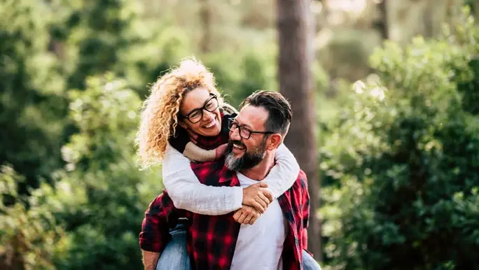 Happy man and woman laughing and enjoying the outdoors and nature