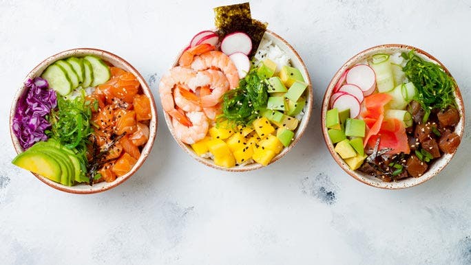 Three protein rich poke bowls with salmon, prawns, tuna, rice and fresh vegetables