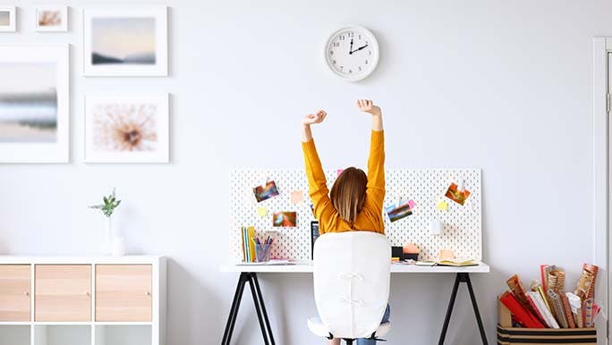 While sitting at her desk, a woman is stretching while having a break to try to stop bringing work stress home. 