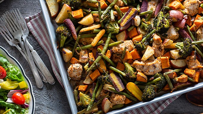 Flatlay of a chicken and vegetable sheet bake promoting the benefits of organic food.