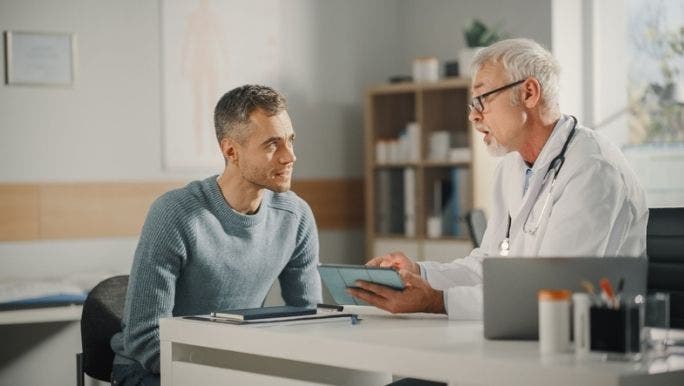 A doctor is speaking with a young man during a medical consultation 