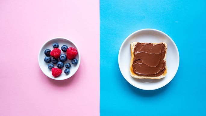 Comparing which sugar is healthy with a plate of berries on the left and a plate with a slice of bread with hazelnut chocolate spread on the right.